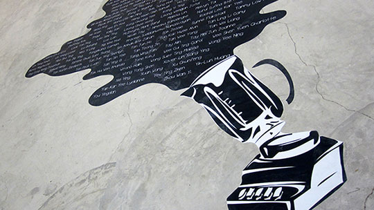 Photograph of a blender spill artwork pasted on the floor, incorporating names of the exhibitors of Random Blends 2011.