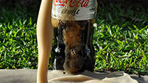 Photograph of a 1.5-litre bottle of Coca-Cola Light with foam erupting out of the bottle's mouth, like a fountain or geyser, shortly after some Mentos candies were dropped into it.